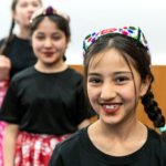 children in Uyghur dress smiling at camera
